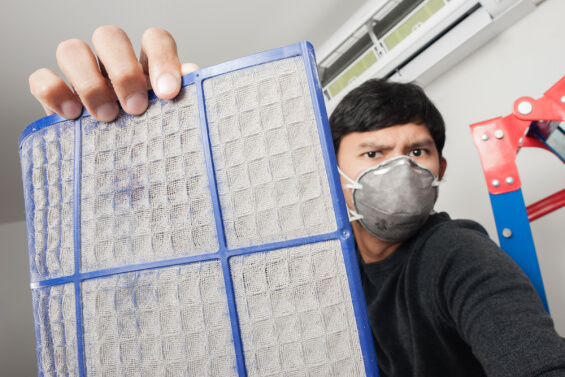 man holding dirty air filter