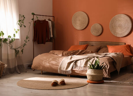 Bed,With,Orange,And,Brown,Linens,In,Stylish,Room,Interior